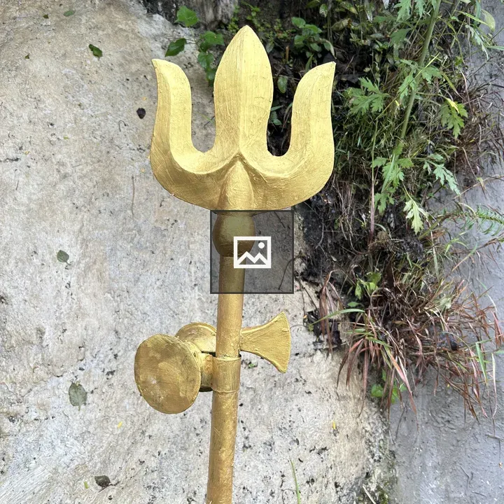Golden trident on rocky surface