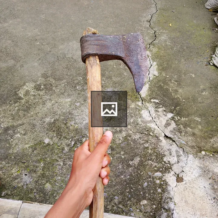 Hand holding a rustic axe