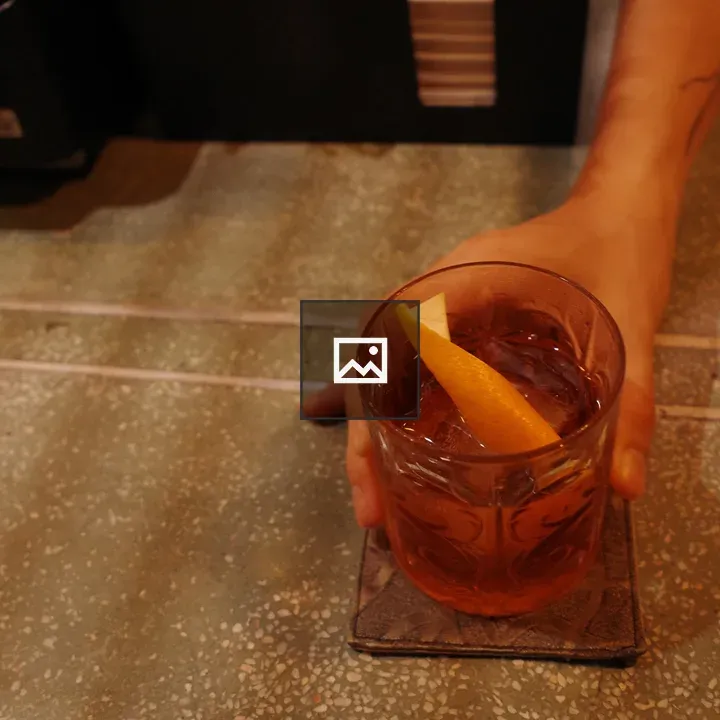 Hand holding a citrus garnish drink