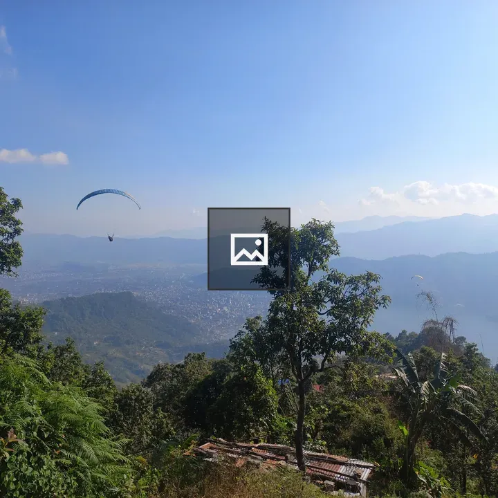 Paraglider Over Mountain Landscape