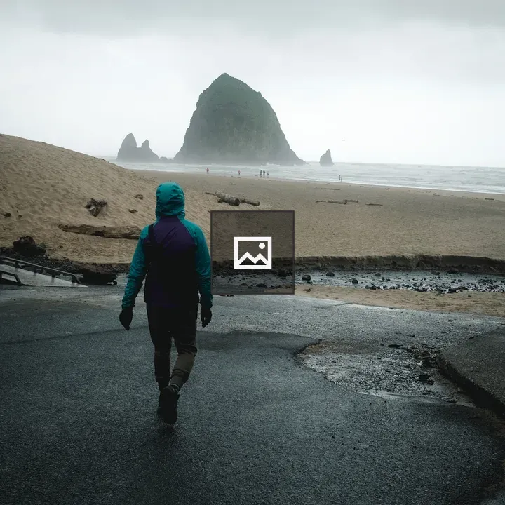 Person walking toward Haystack Rock