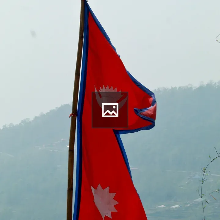 Nepal flag on mountain backdrop