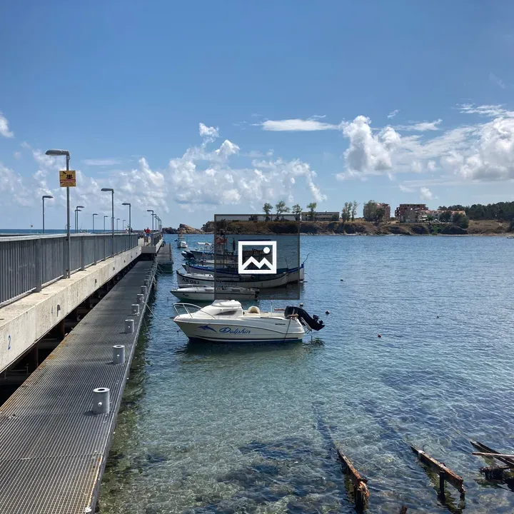 Pier with moored boats and blue sea