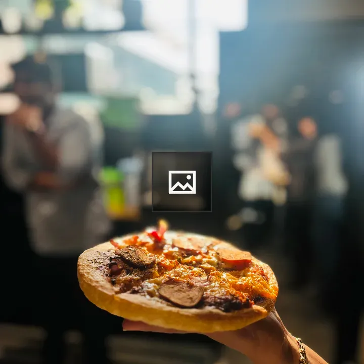 Pizza on a hand, indoor scene