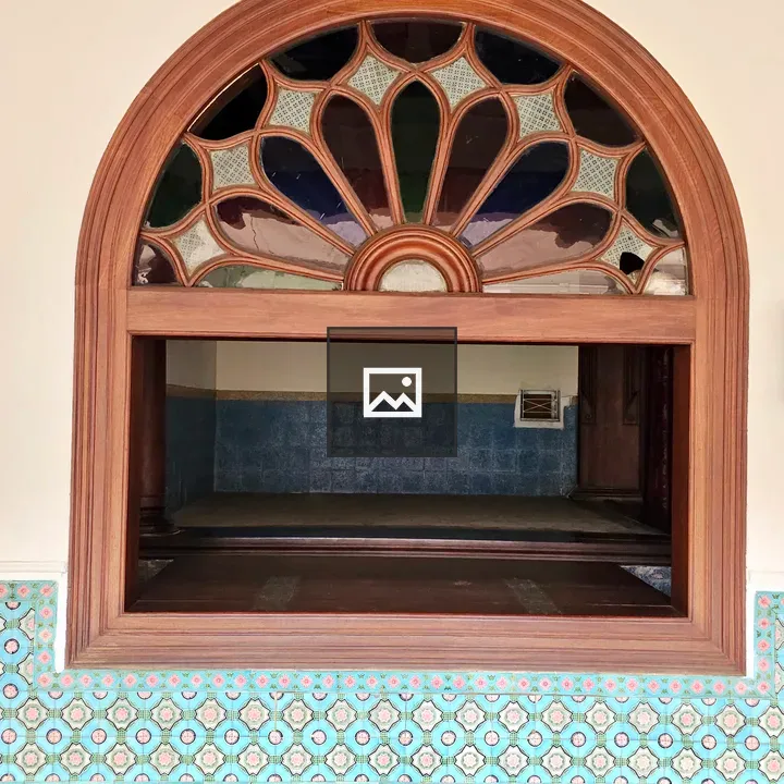 Arched wooden window with decorative glass