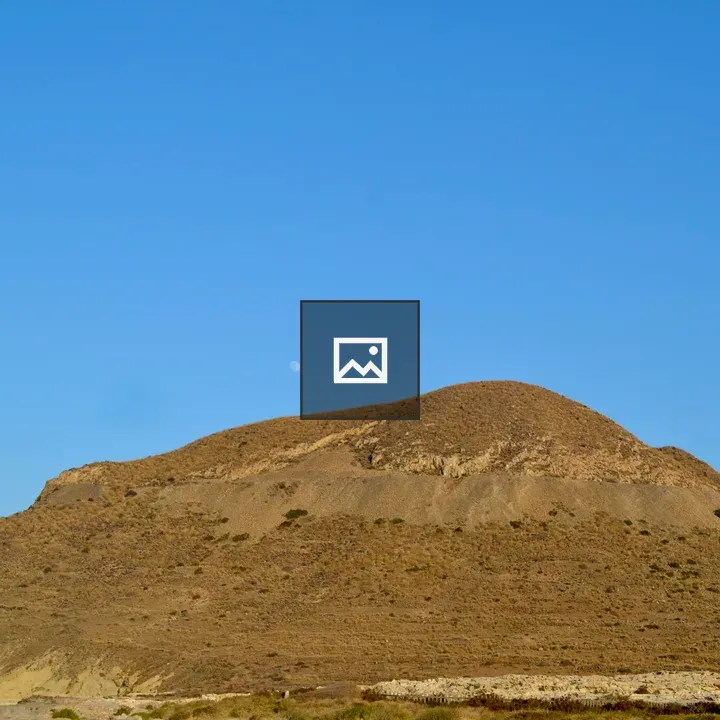 Dry brown hill under blue sky