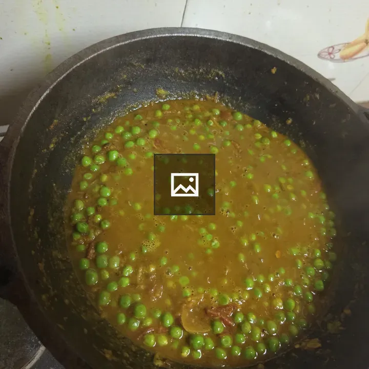 Pot of curry with green peas