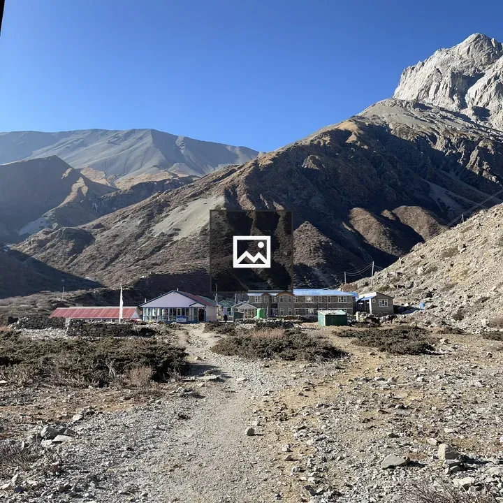 Mountain village below brown hills