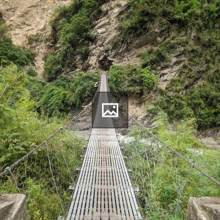 Narrow metal bridge over rocky landscape