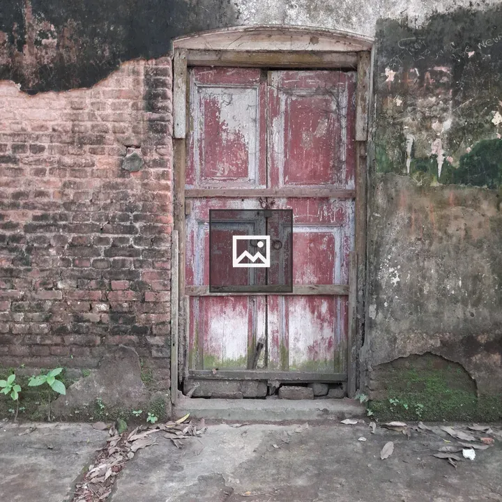 Red wooden door in weathered wall