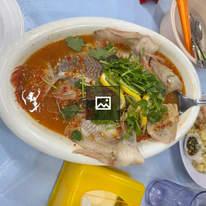 Plate of steamed fish with lemon and herbs
