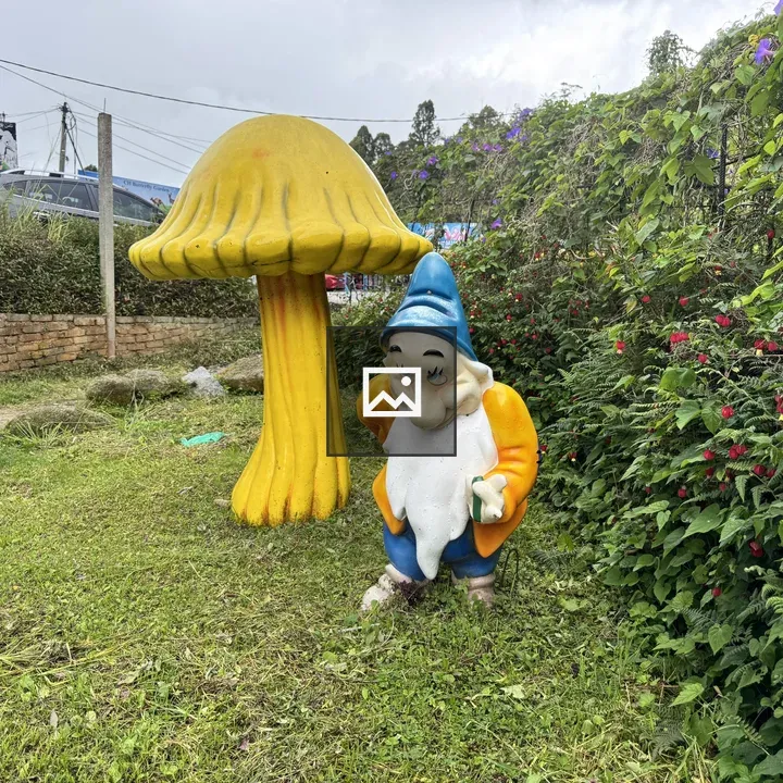 Garden gnome with mushroom sculpture
