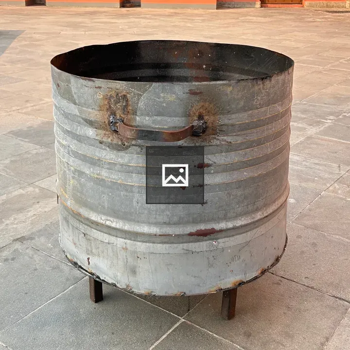 Round metal barrel on stone floor