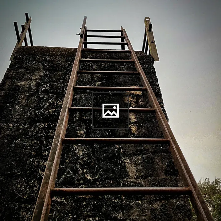 Rusty ladder against stone tower