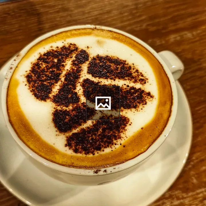 Cup of cappuccino with leaf cocoa art