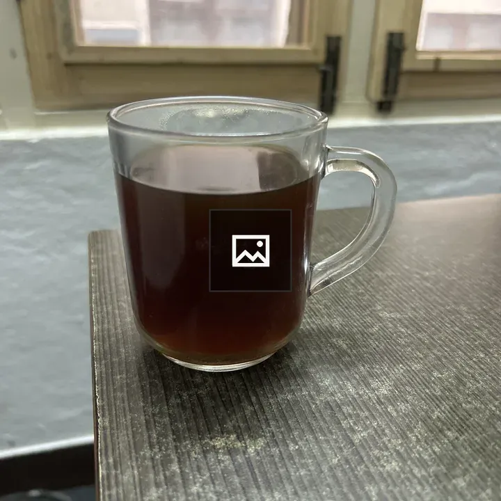 Glass mug of coffee on wooden table