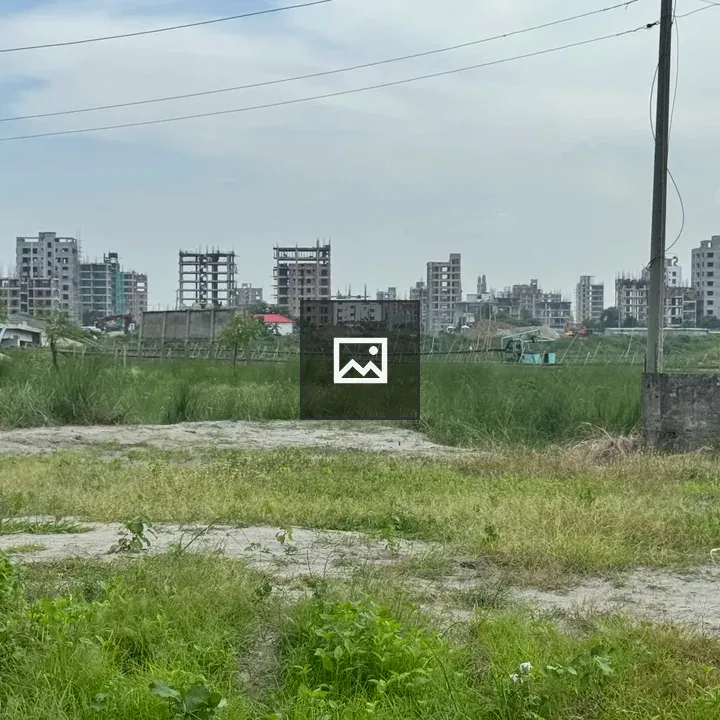 Grassy field with unfinished buildings