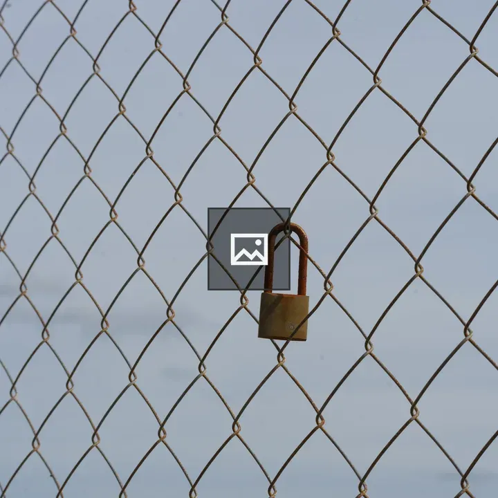 Rusty padlock on fence
