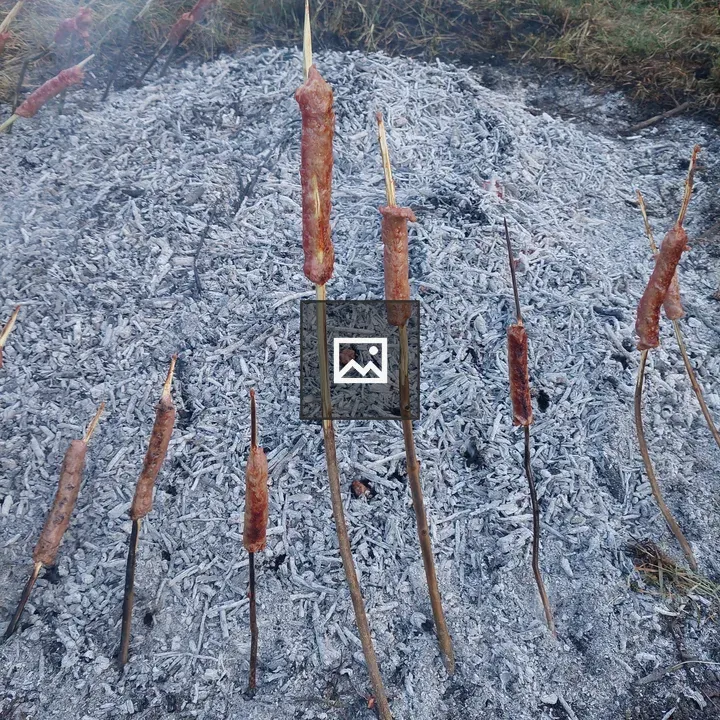 Pile of ash with sticks and sausages
