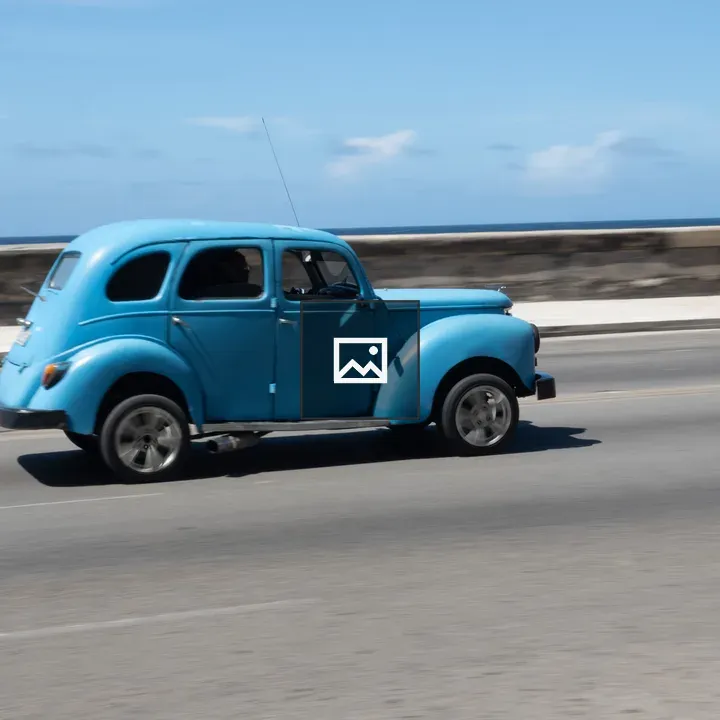 Vintage blue car on coastal road
