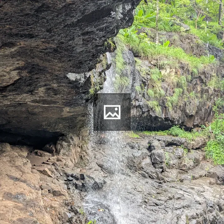 Waterfall over rocky overhang