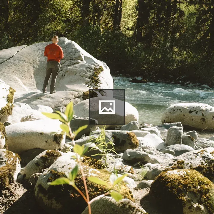 Person on a Boulder by River