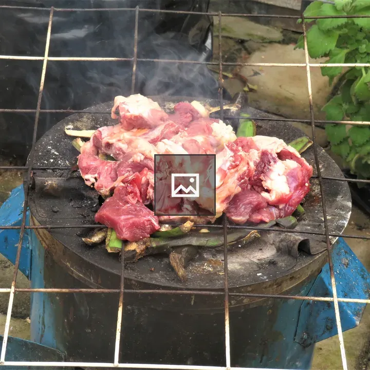 Raw meat grilling on round grate