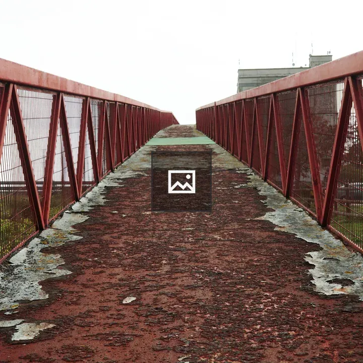 Red rusty bridge over road