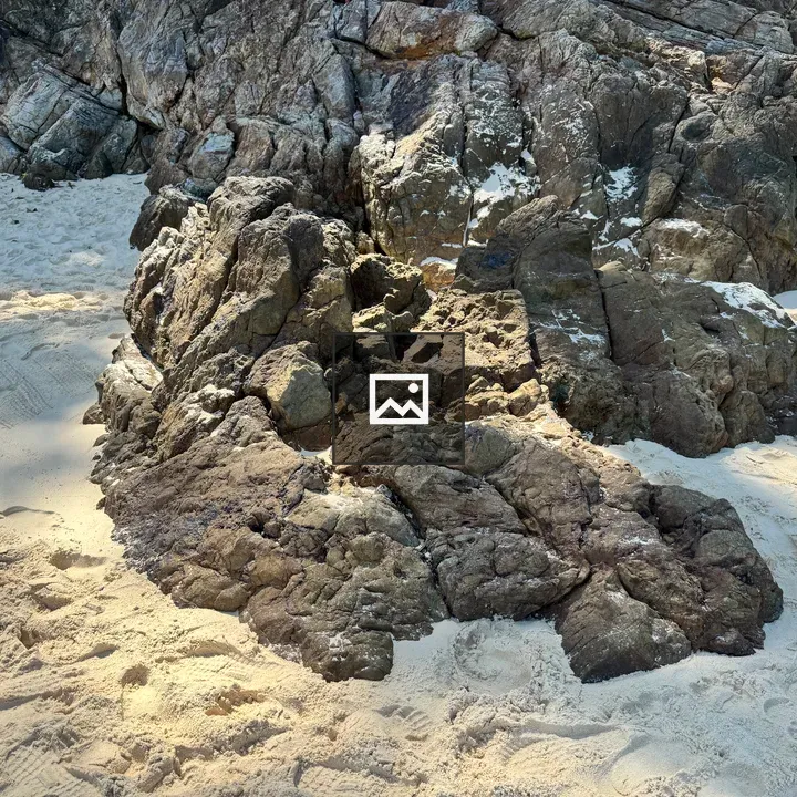 Rock on white sand beach