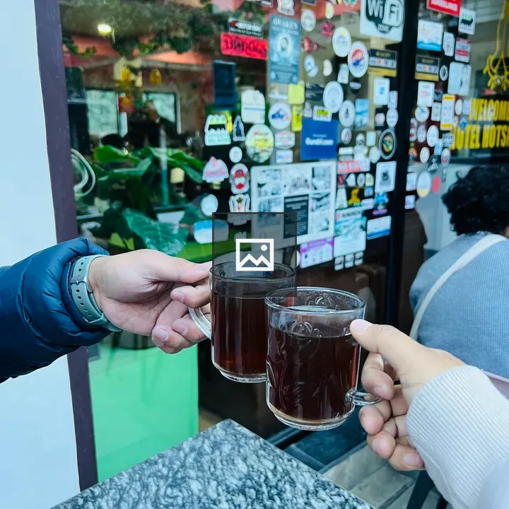 Two hands toasting with tea mugs