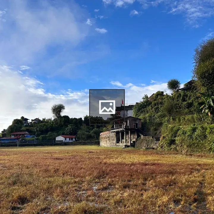 Landscape field with hills and buildings