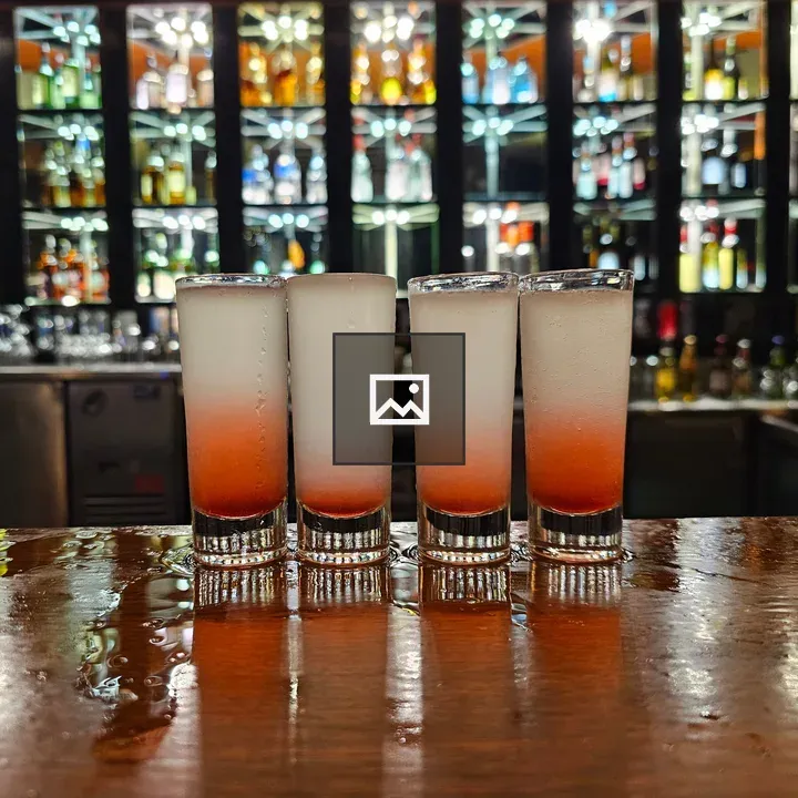 Four glasses of shooters on bar counter