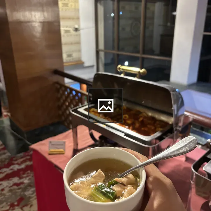 Hand holding bowl of clear broth