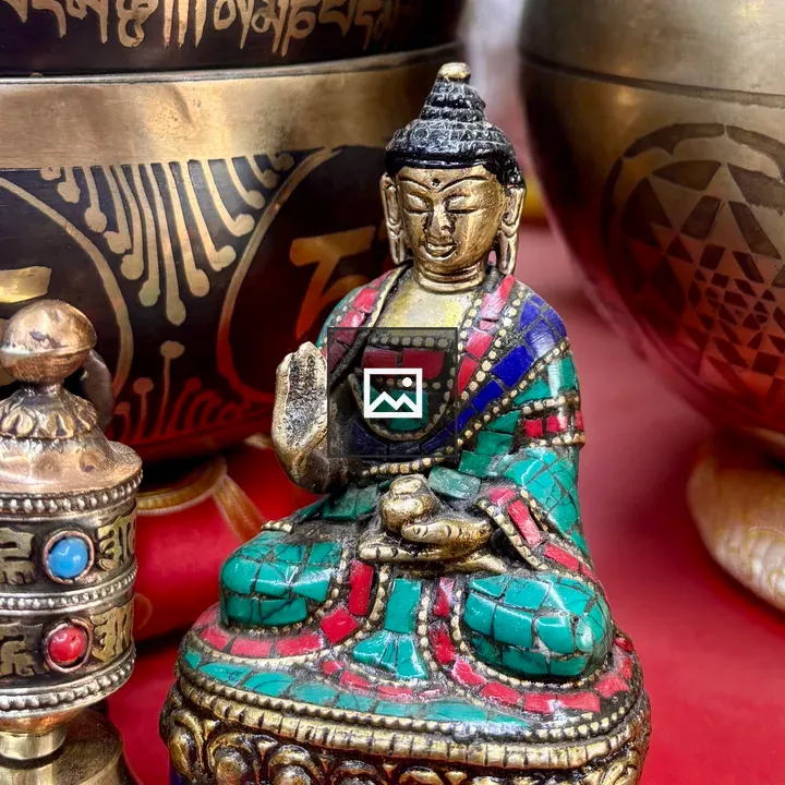 Seated Buddha statue with prayer wheel
