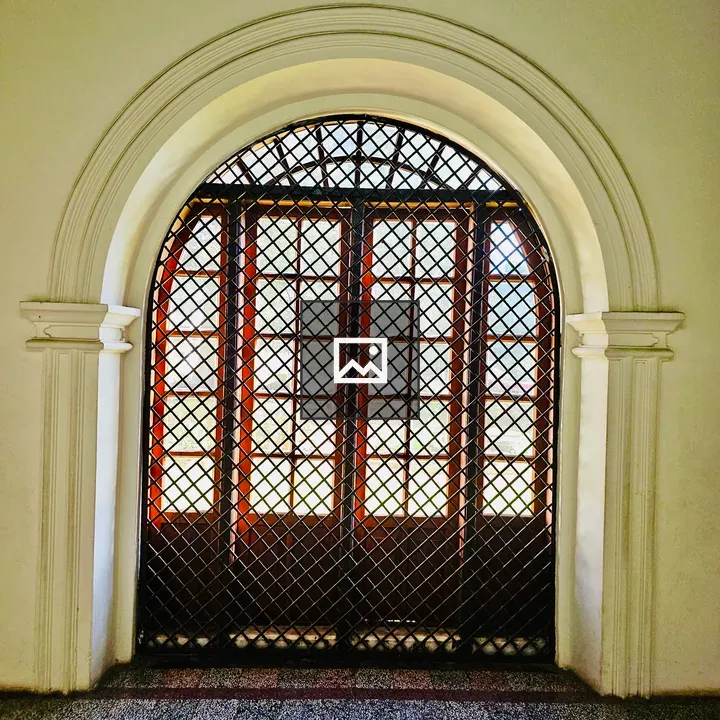 Arched wooden window with grill