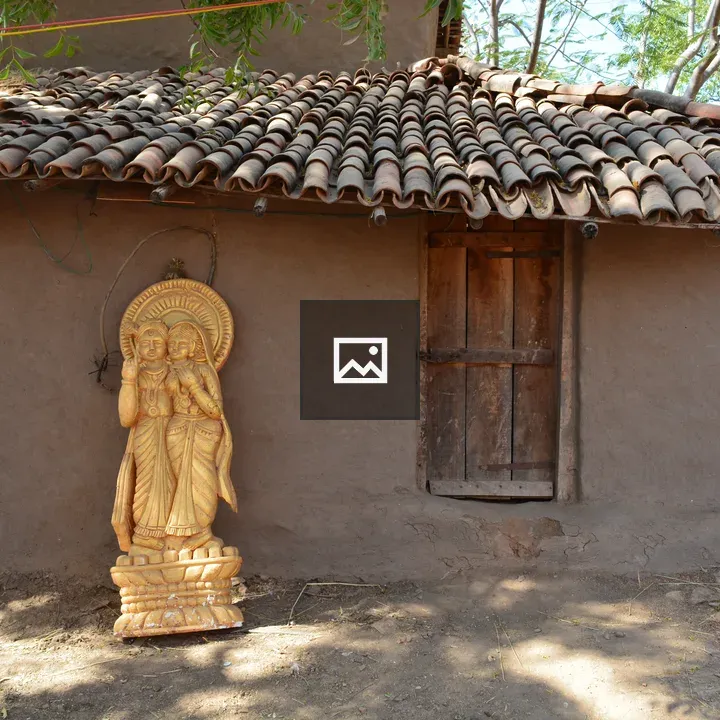 Golden statue with village backdrop