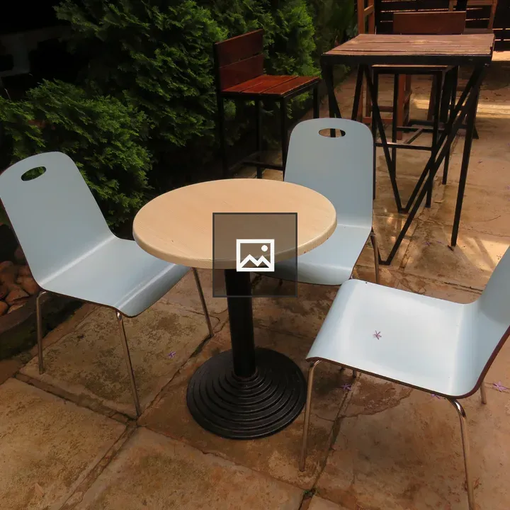 Three chairs around round wooden table
