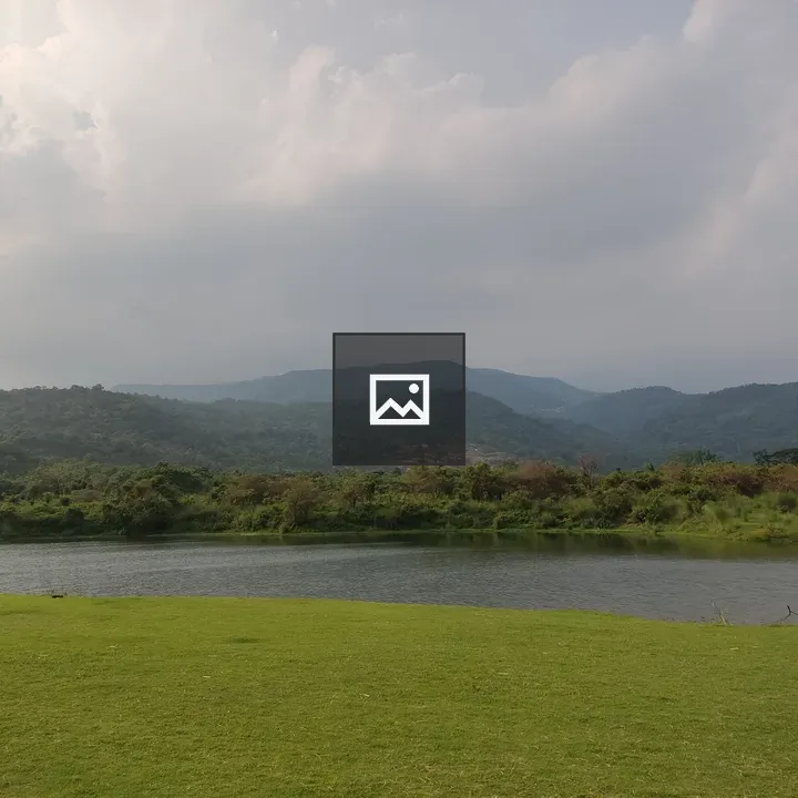 Green field and lake with mountains