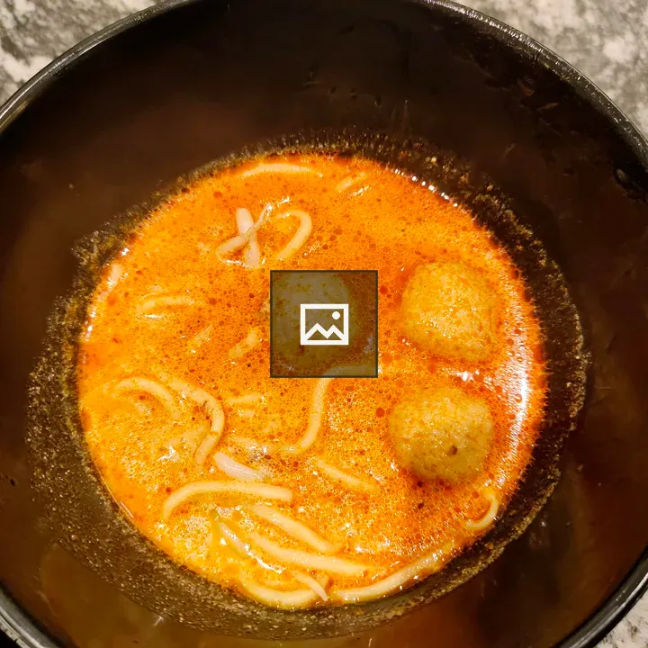 Bowl of soup with noodles and meatballs