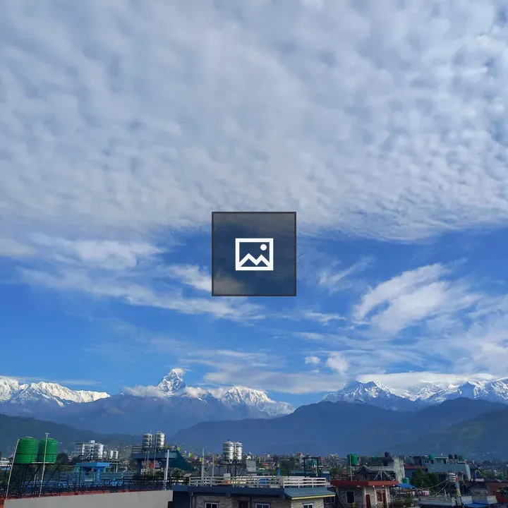 Snow-capped Mountains Over City Roofs