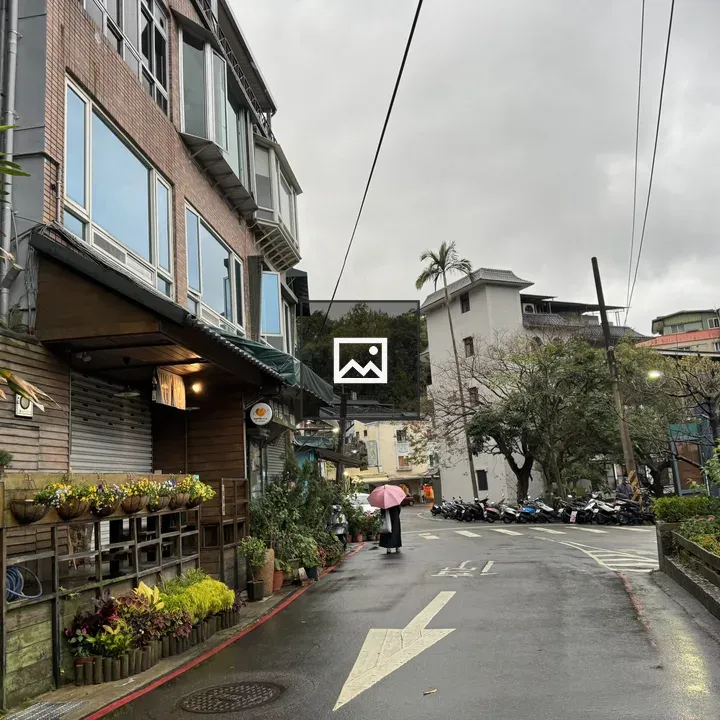 Rainy street with pink umbrella