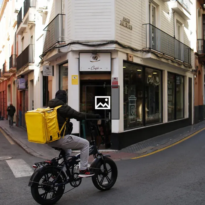 Person riding bicycle with yellow backpack