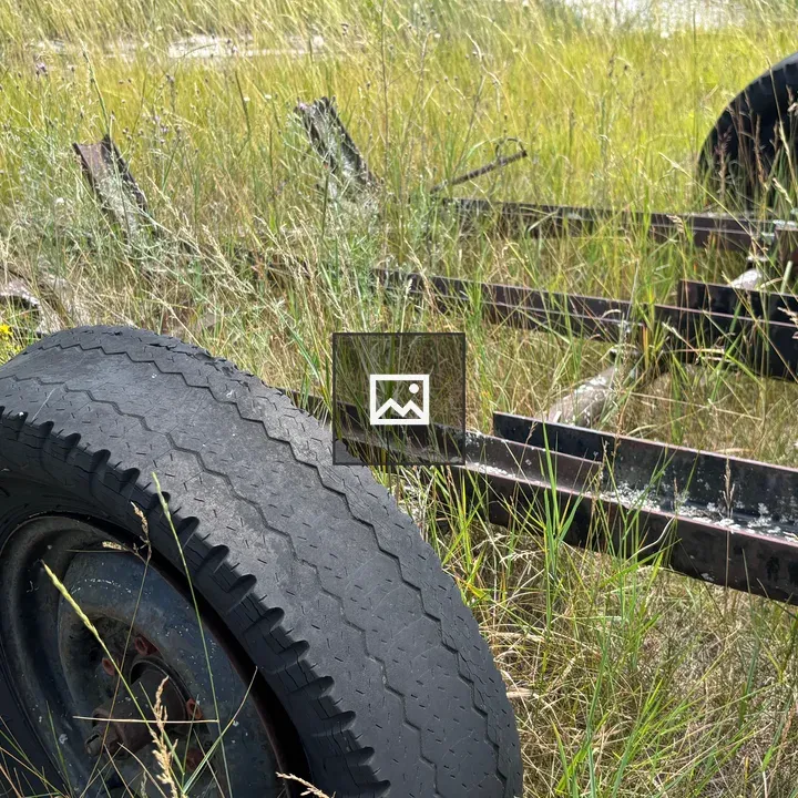 Old motorcycle trailer in field