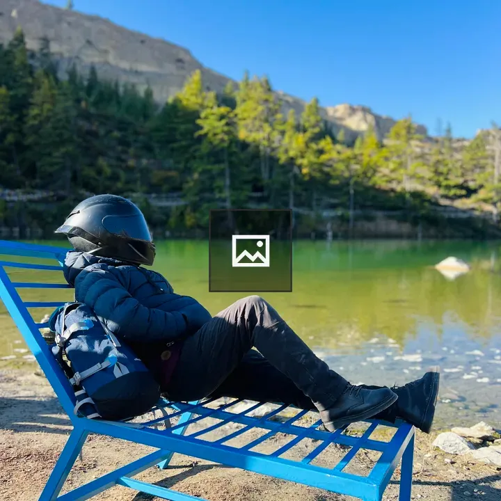 Person in Black Helmet Reclining by Lake