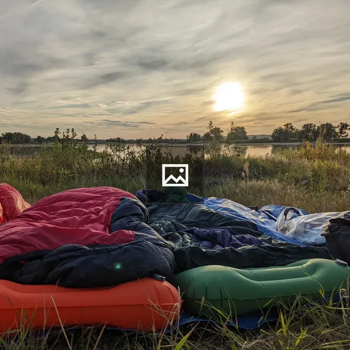 Sleeping setup by the river at sunset