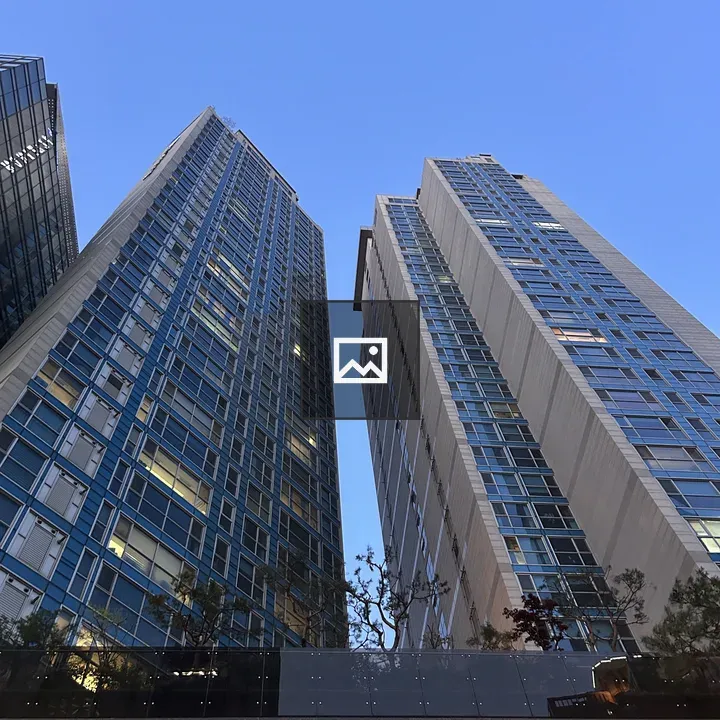 Two tall skyscrapers against blue sky