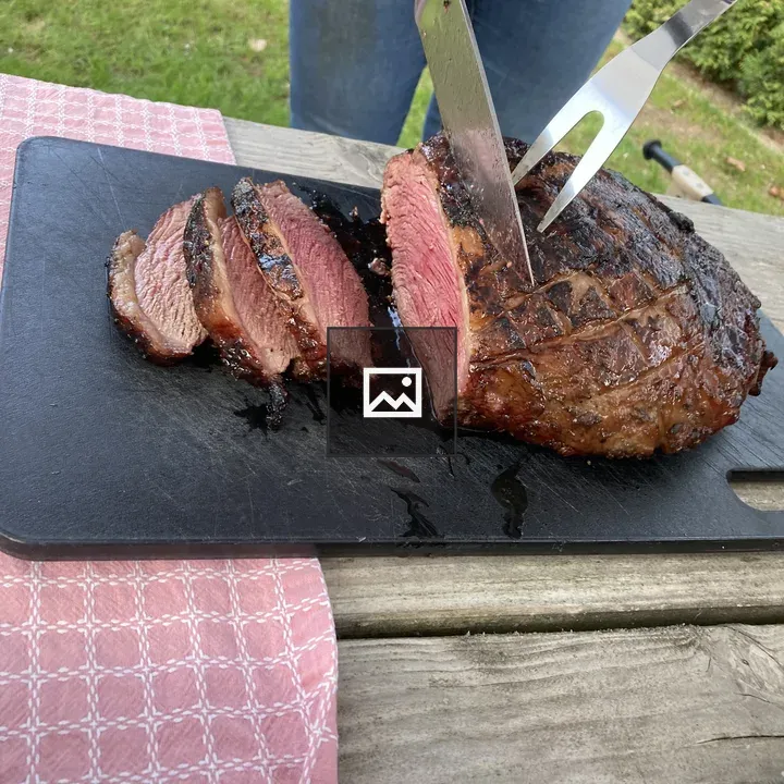 Picanha steak being cut on board