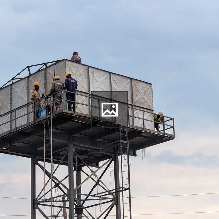 Four men fixing water tank