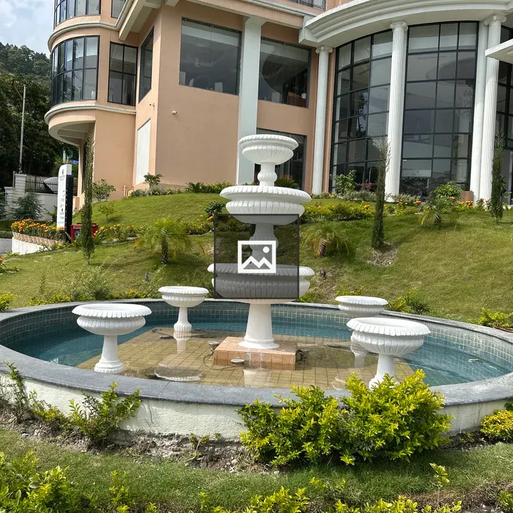 Tiered white fountain in circular pool