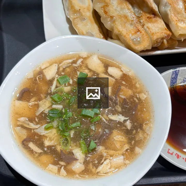 Bowl of savory broth with tofu and meat